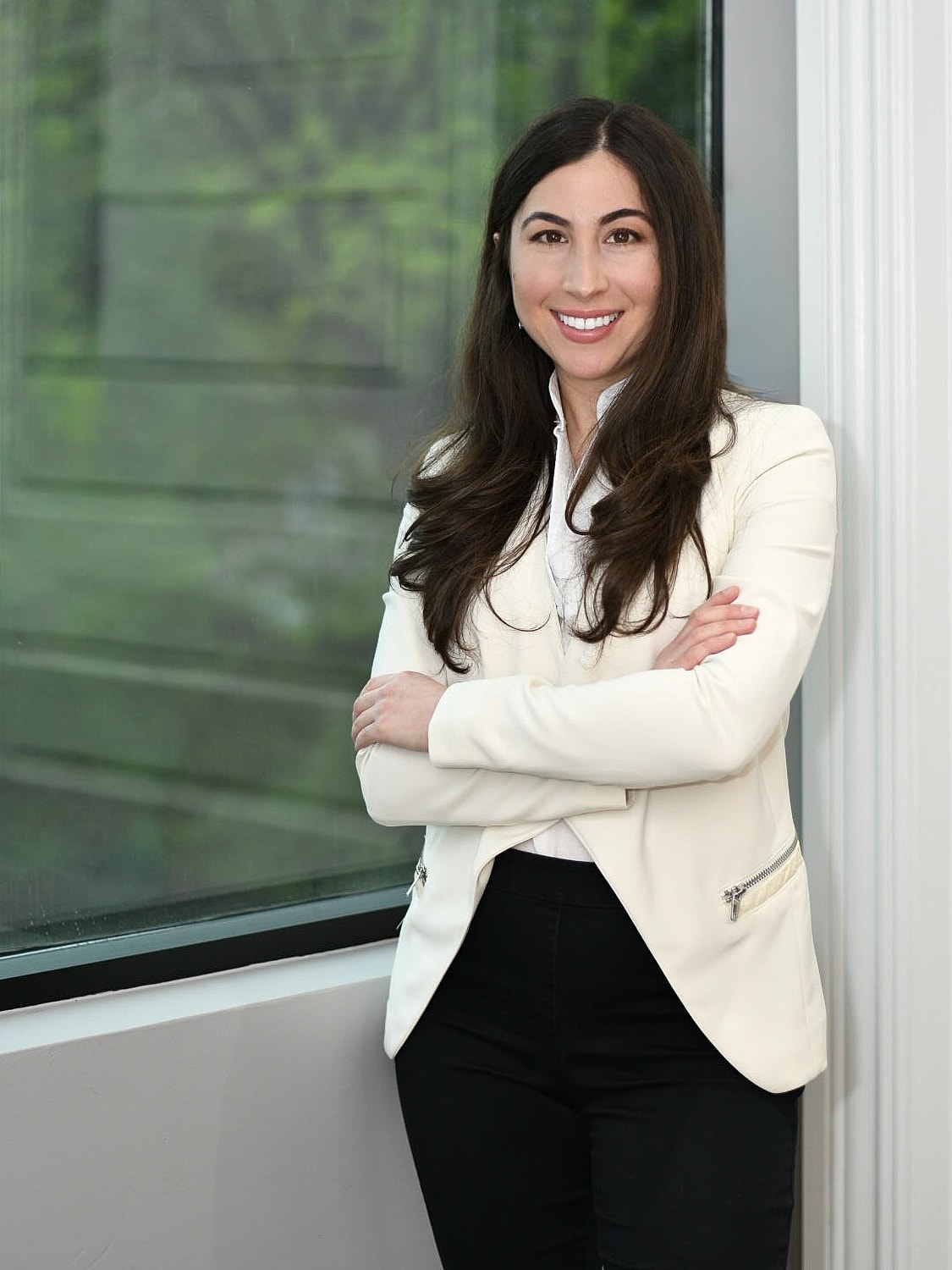 Professional woman smiling by a window.
