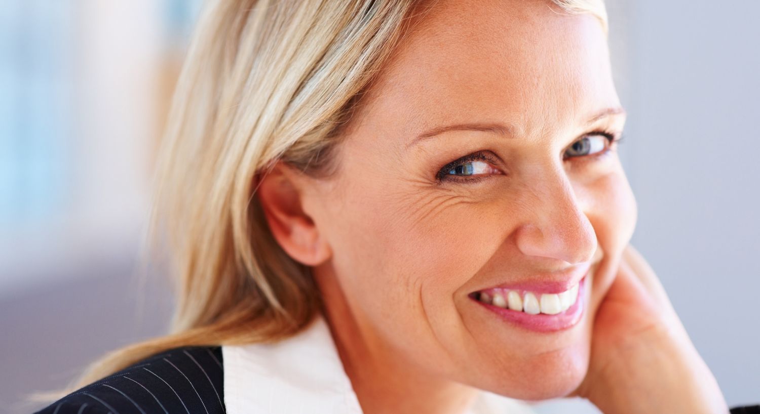 Smiling woman with blonde hair in professional setting.