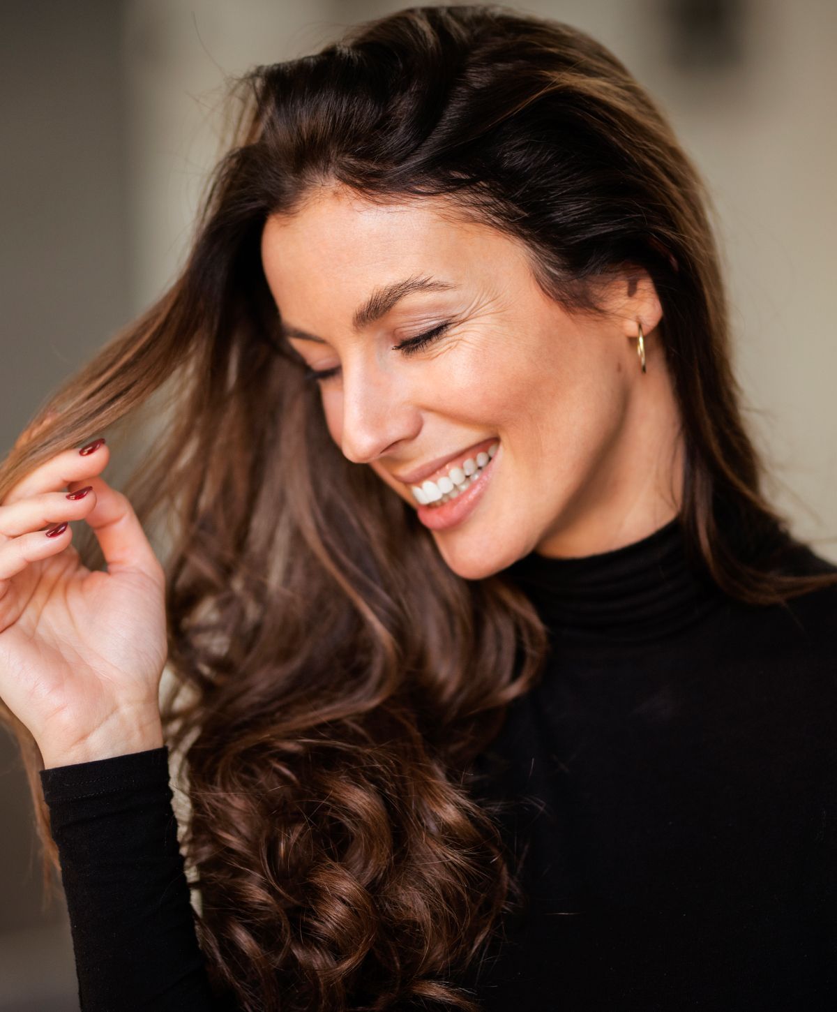 Smiling woman with long, wavy hair.