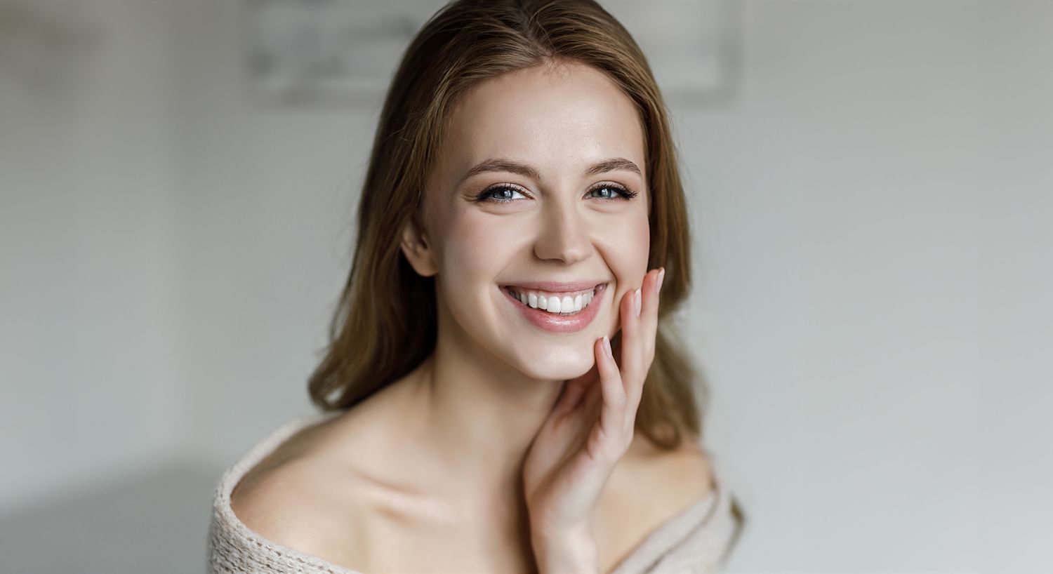 Smiling woman with long hair in natural light.