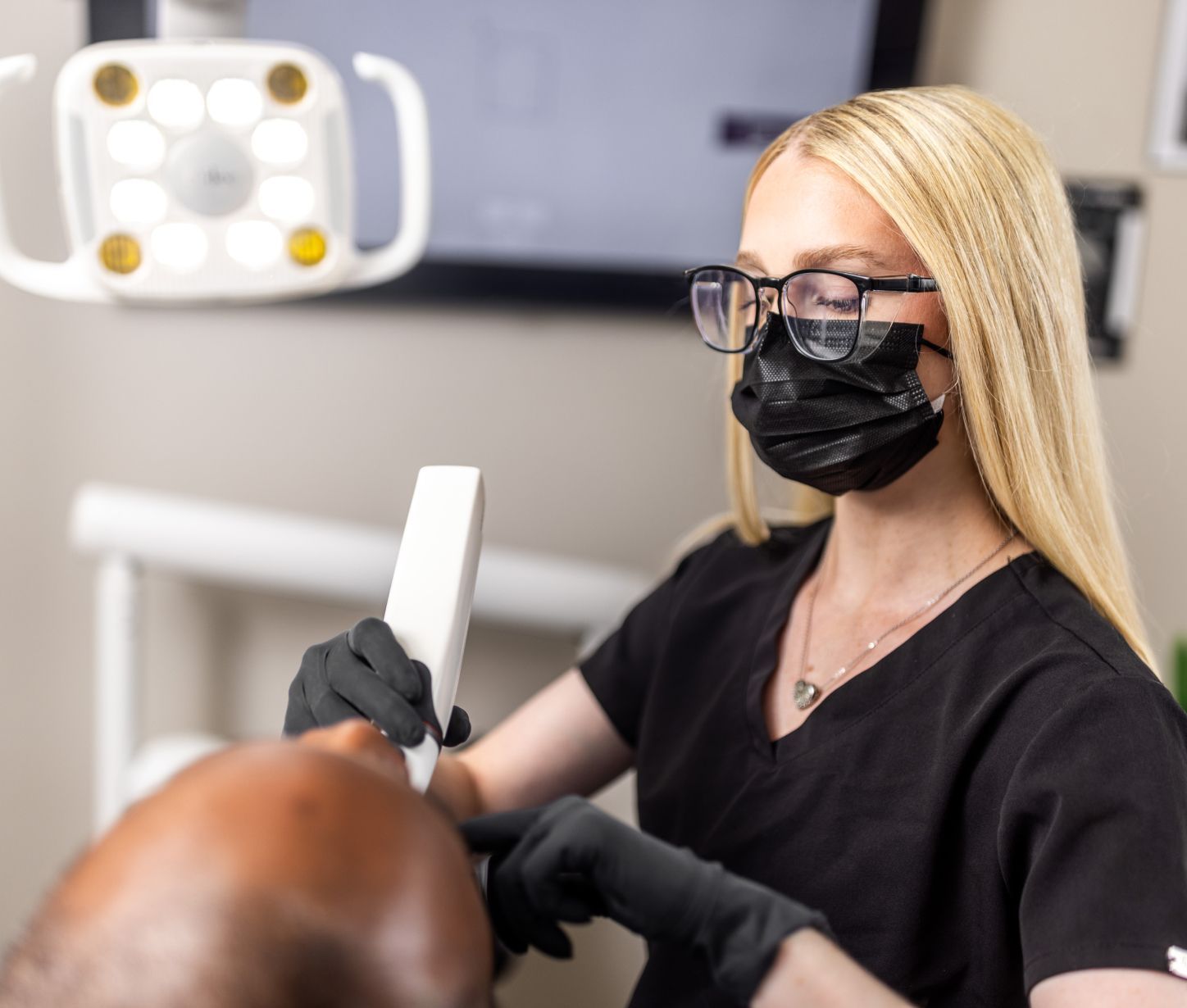 Dental professional assisting patient with treatment.