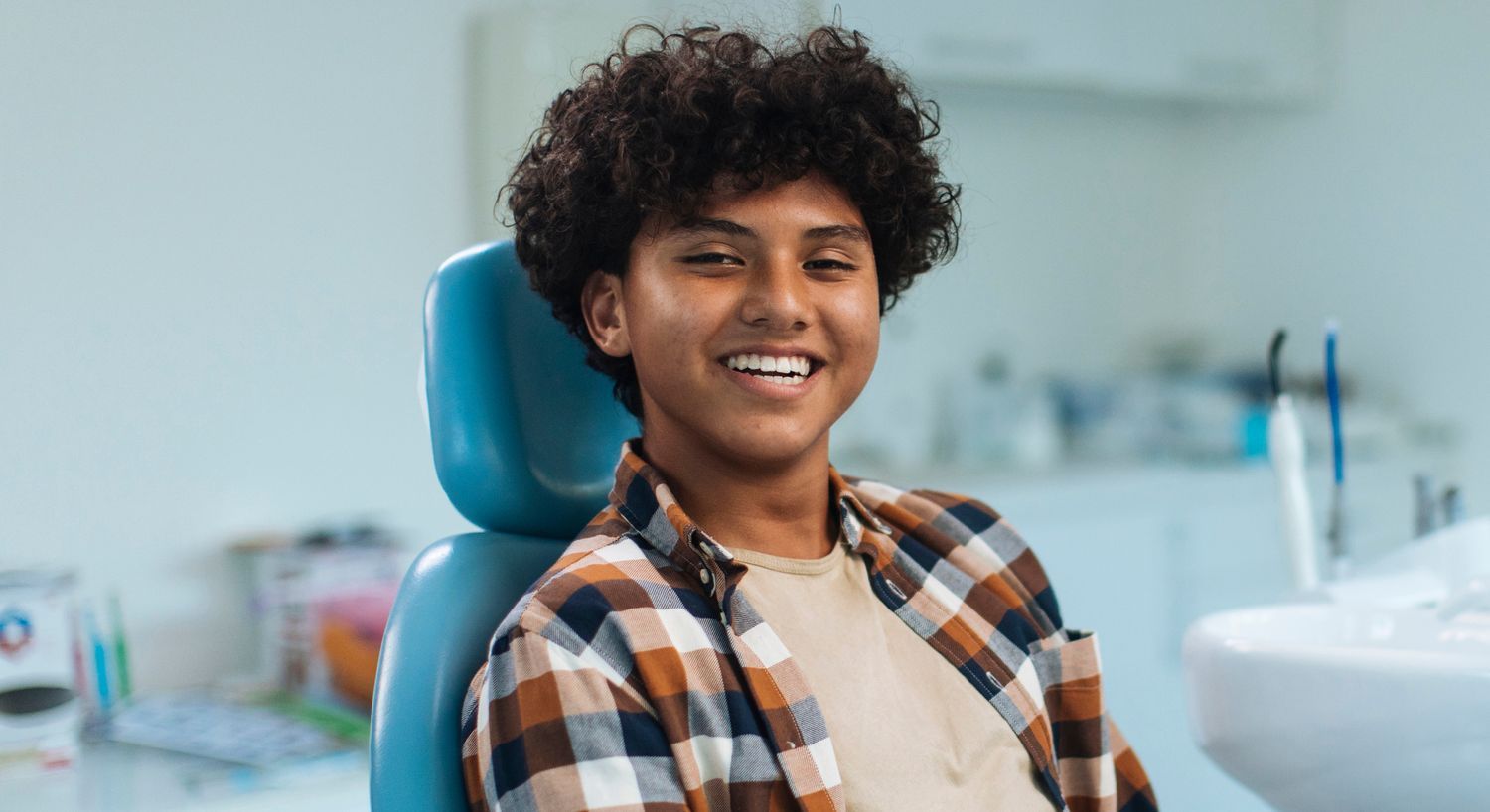 Smiling boy at dentist office, relaxed and happy.