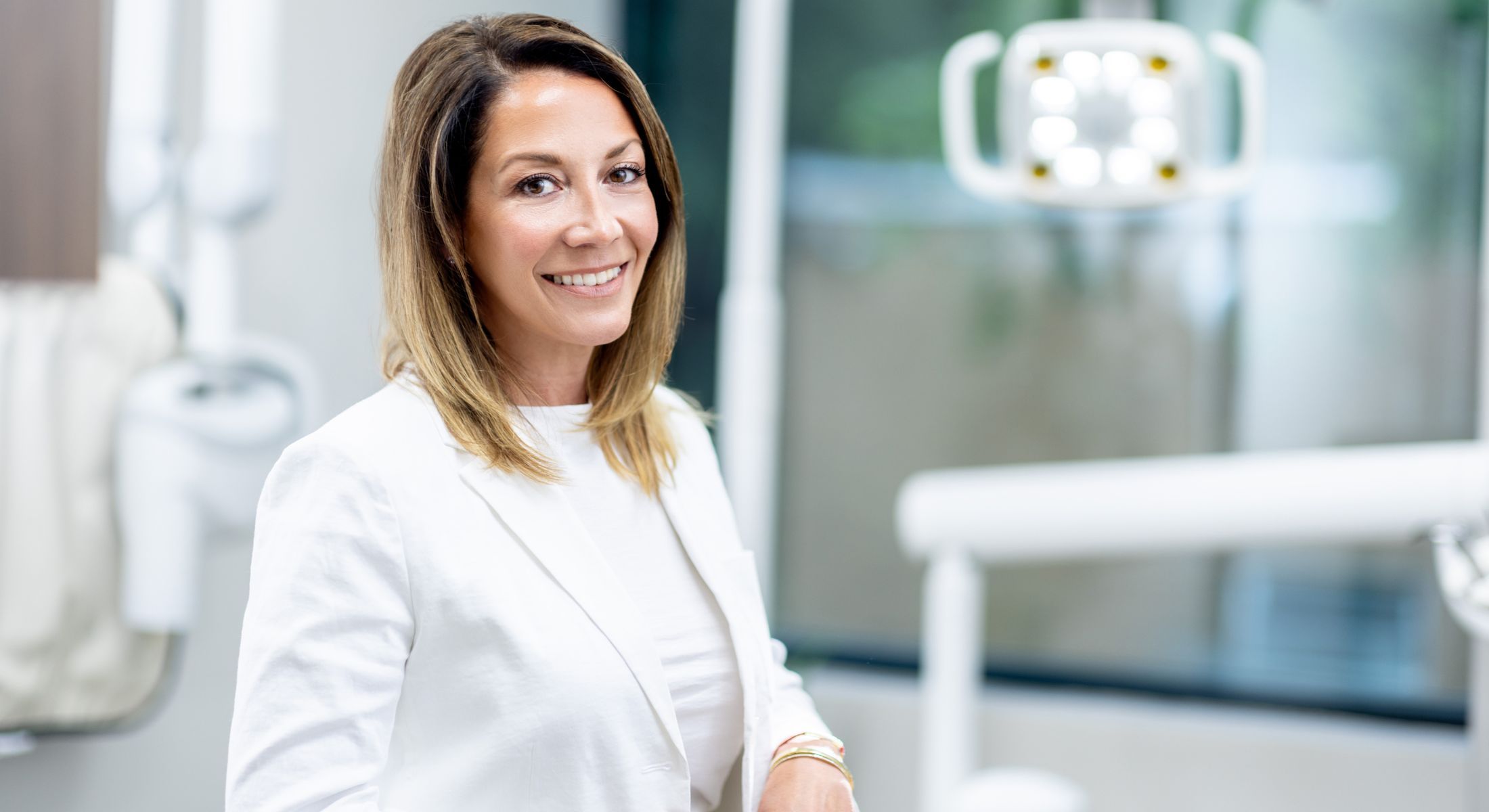 Smiling woman in dental office setting.