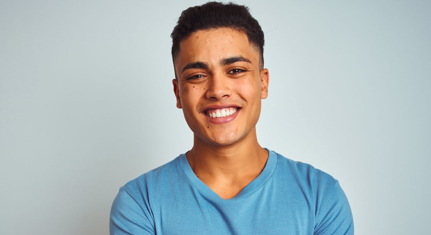 Smiling young man in a blue t-shirt.