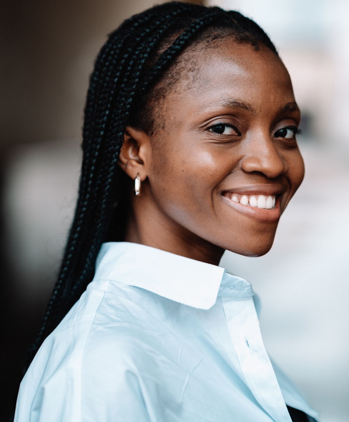 Smiling woman with braided hair in profile.