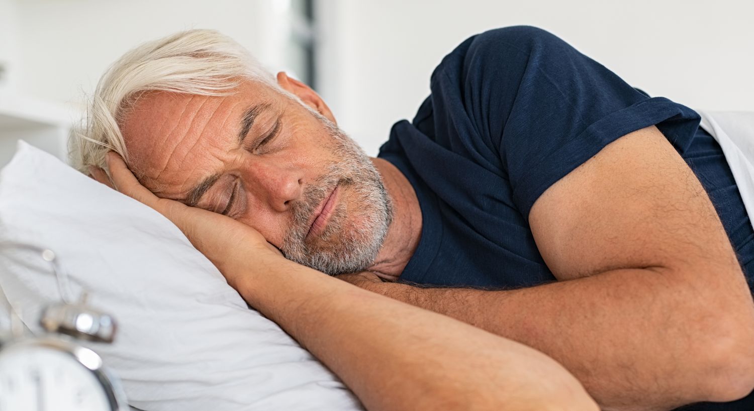 Man sleeping peacefully on a bed.