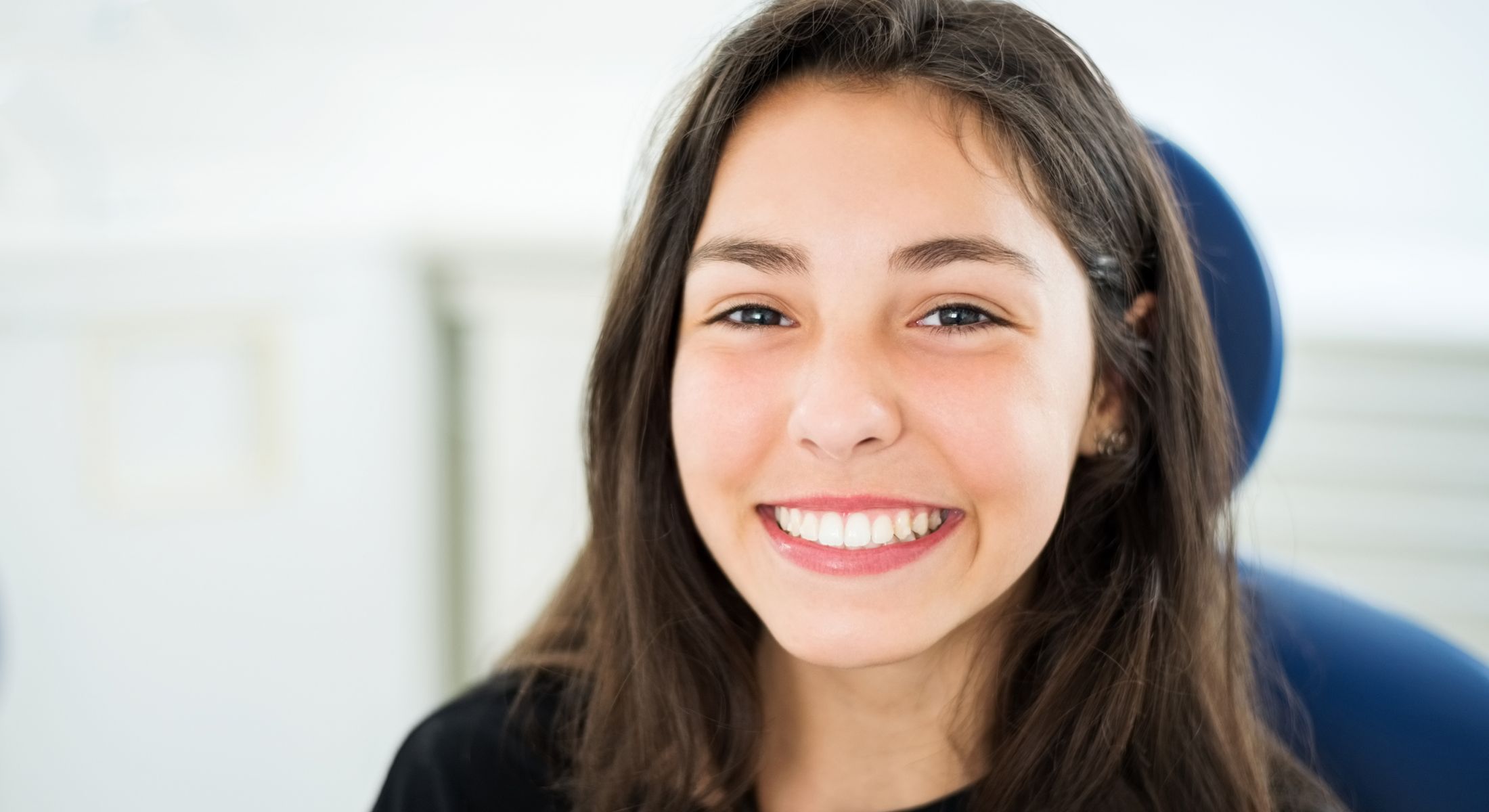 Smiling girl in dental office setting.